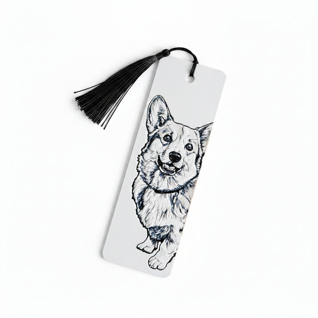 A white rectangular bookmark with a black tassel, featuring a black line art sketch of a corgi dog on the front, photographed against a light beige textured background.