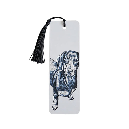 A white rectangular bookmark with a black tassel at the top, featuring a black ink-style illustration of a dachshund dog on the front, shown against a white background.