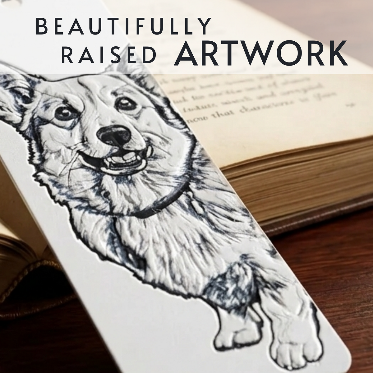 A white rectangular bookmark featuring a detailed black-and-white raised ink-style illustration of a dog, placed over an open book on a wooden surface. Large text at the top reads 'BEAUTIFULLY RAISED ARTWORK.