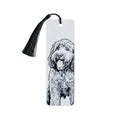 A white rectangular bookmark with a black tassel and a black-and-white illustrated doodle dog portrait, photographed on a light beige textured background.